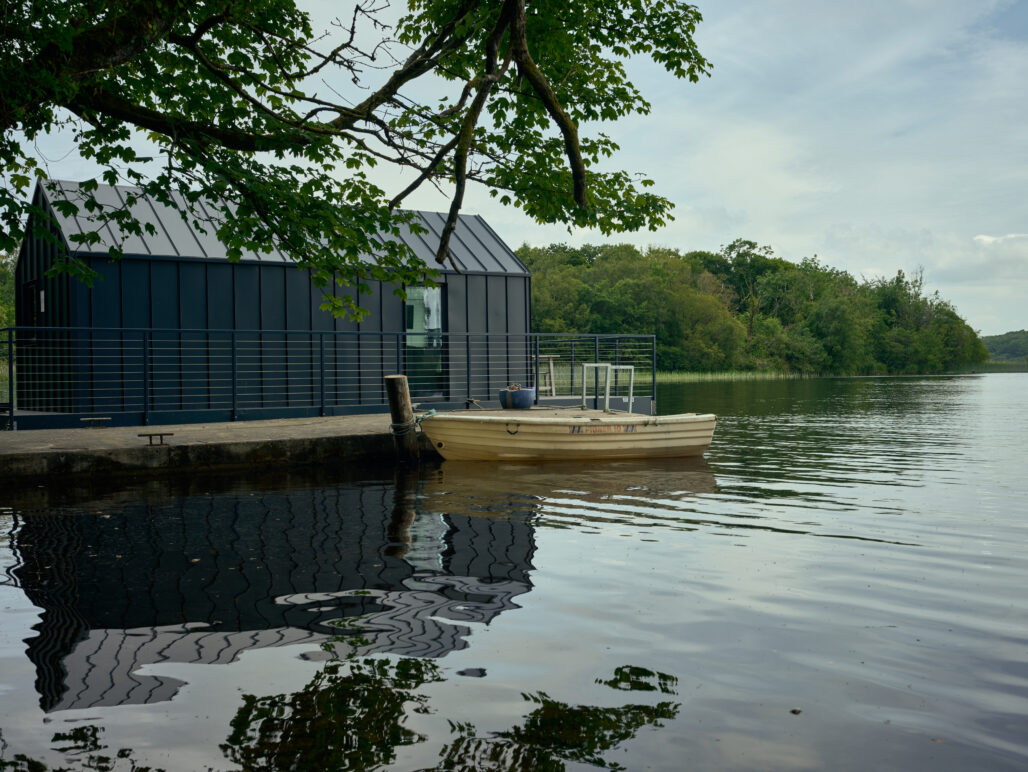 Side view of a C250 houseboat on a lake in Fermanagh with pontoon and boat in foreground