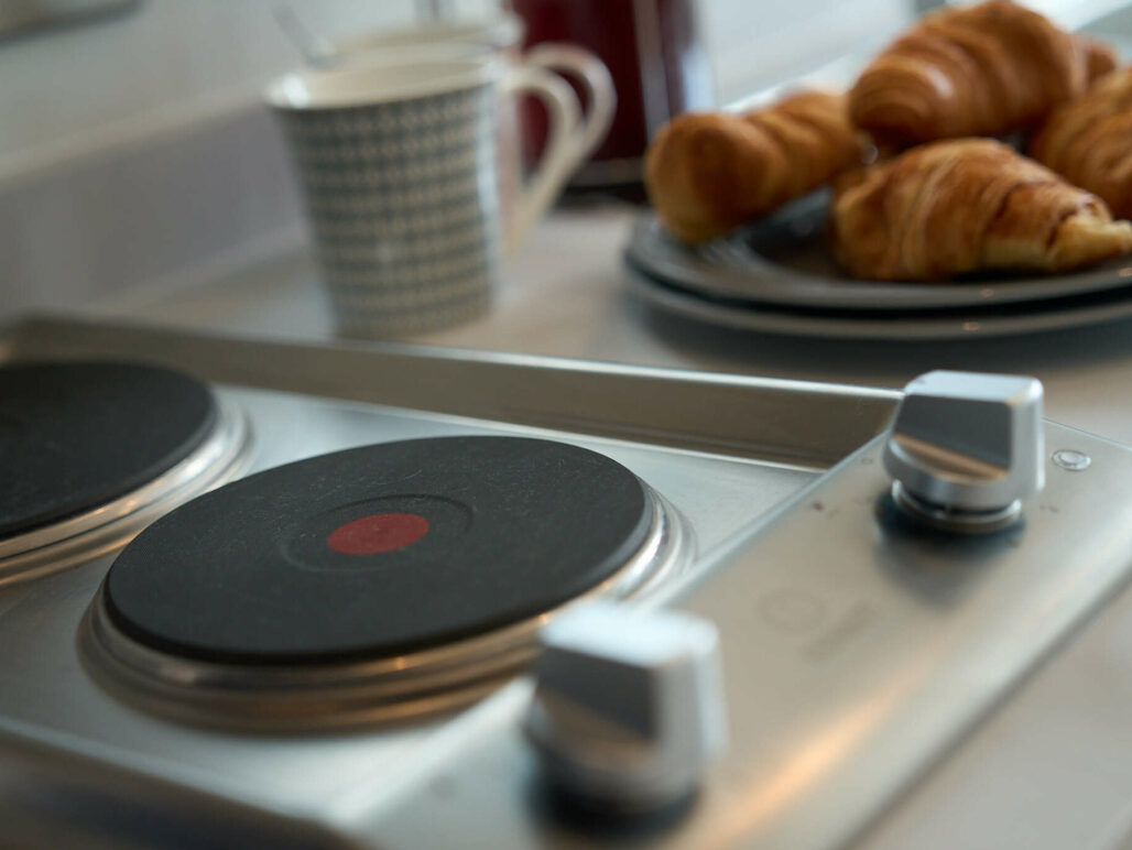 Close up of kitchen hob with croissants and coffee